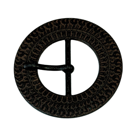 Runde Schnalle aus dunkelbraun-schwarzem Metall mit umlaufendem Wellenmuster und mittigem Dorn