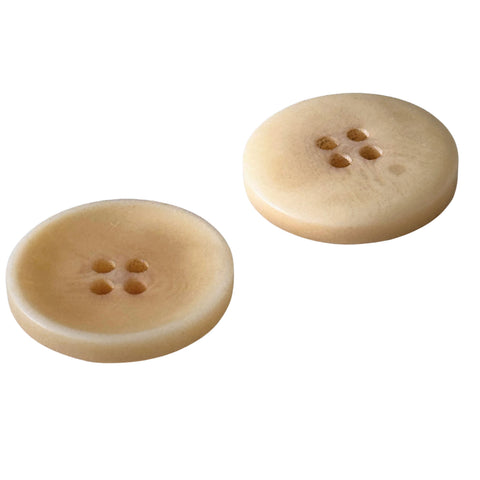 Knopf beige matt, 4 Loecher, links Vorderseite mit vertiefter Mulde, rechts leicht gewoelbte Rueckseite